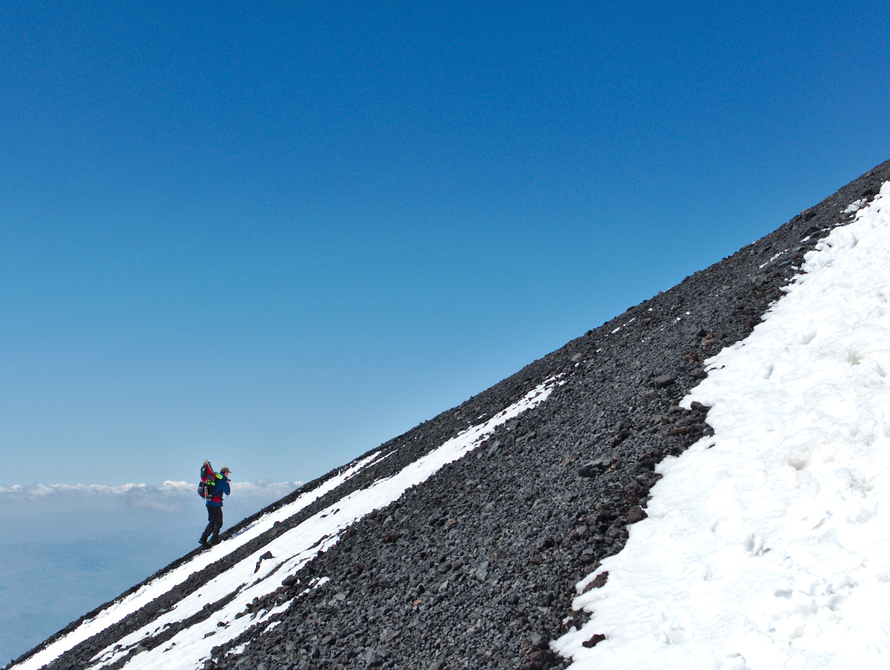 A tourist climbing one of the craters of the Etna vulcan, Sicily, Italy.